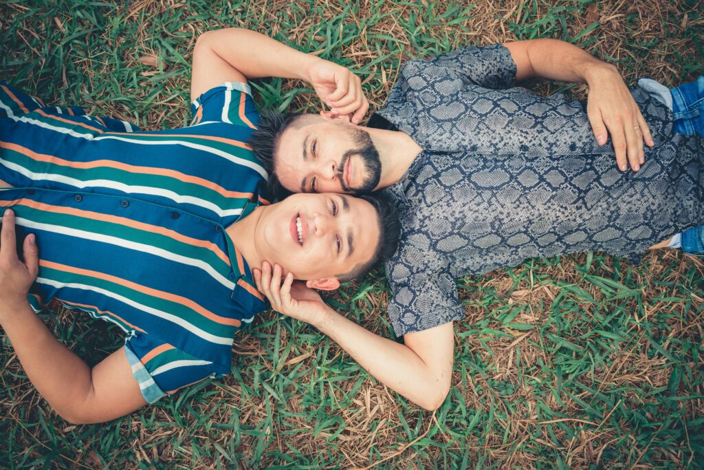 pexels photo 2440069 2440069 A happy couple enjoys a relaxing moment lying on grass outdoors in summer.